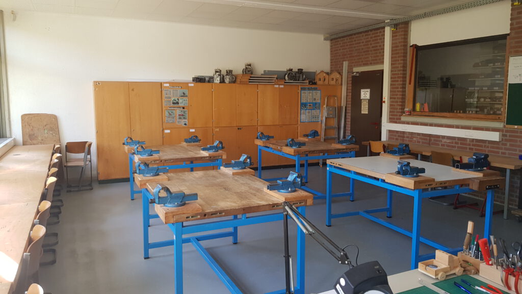 4Werkbänke mit der Möglichkeit, das Werkstück einzuspannen. Im Hintergrund Materialschränke.