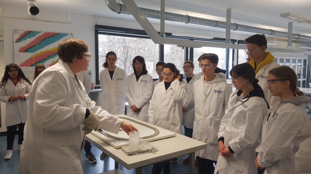 Schüler*innen beobachten ein Experiment zum Thema Supraleiter